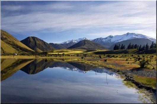 canterbury new zealand with a lagoon and the mountains reflected in the water