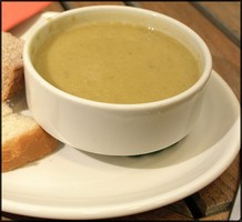 a bowl of courgette soup with crusty bread