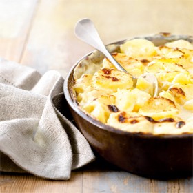 a bowl of creamy layered potato bake