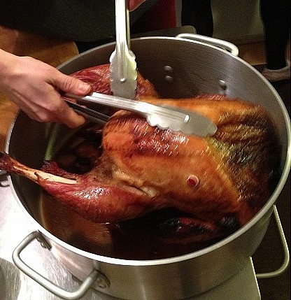 Deep fried turkey being taken out of the pot.htt