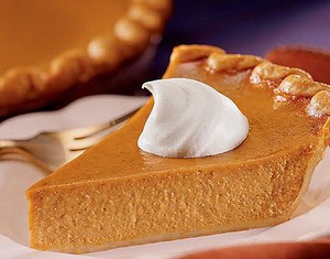 A slice of luxury pumpkin pie with cream.