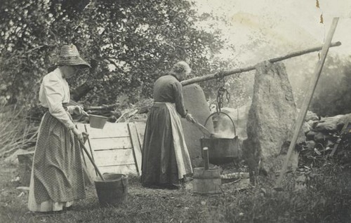 2 women making soap the old fashioned way over an open fire