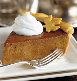 A wedge of pumpkin pie topped with cream.