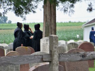 3 Amish women dressed in black at an Amish funeral