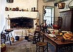 A colonial country kichen with fireplace and utensils.