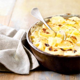 a bowl of creamy layered potato bake