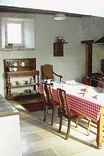 A traditional French country kitchen with a red and white check tablecloth.
