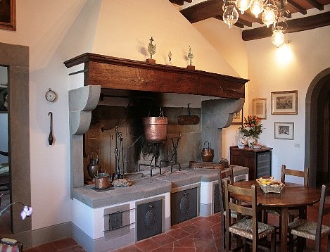 A traditional Italian kitchen with a fireplace for cooking.