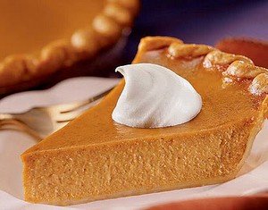 A slice of luxury pumpkin pie with cream.