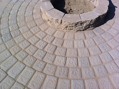 Brushing in polymeric sand between the pavers on the patio.