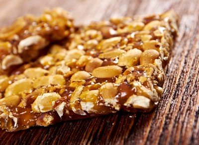 Peanut brittle freshly cut lying on a wooden counter top