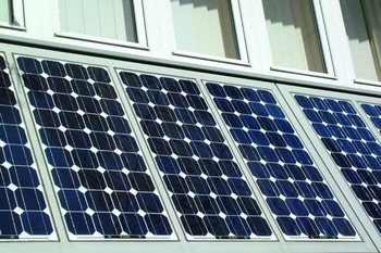 A panel of photovoltaic cells on the side of a building