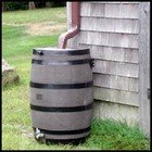 A wooden barrel catching rain water.